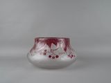 a close up of a glass vase with a red design on it