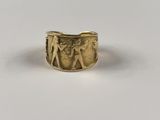 un gros plan d'une bague en or sur laquelle sont gravés un homme et une femme