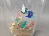 a glass vase filled with different colored fish and rocks