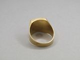 a close up of a gold ring on a gray surface