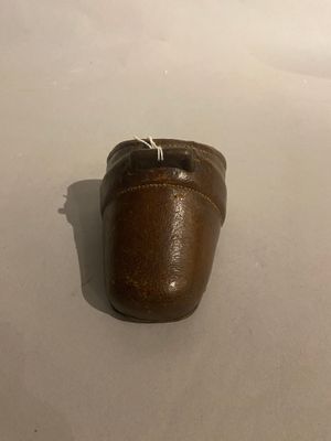 a small brown shoe that is on a white surface