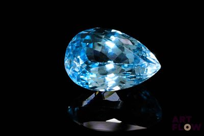 gros plan d'un diamant bleu sur une surface noire