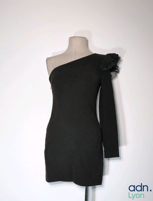 une robe noire exposée sur un mannequin posé sur un présentoir