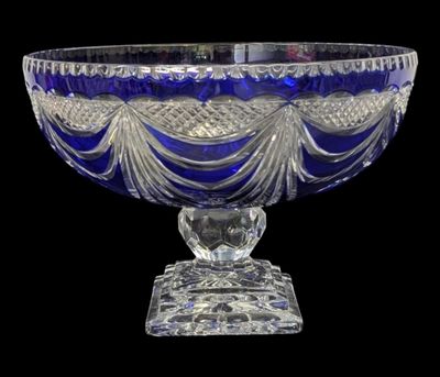 an image of a blue glass bowl on a stand on a black background