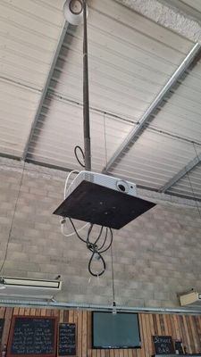 a ceiling mounted projector in the middle of a room