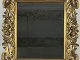 a gold framed mirror on a wall next to a white wall