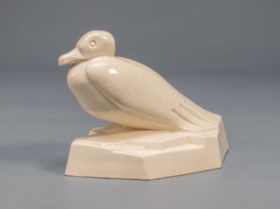 a white bird sitting on top of a white base