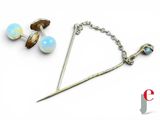 a pair of earrings and a stick on a white surface