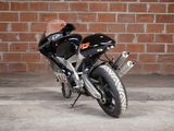 a black motorcycle parked in front of a brick wall