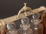 four glass decanters sitting on a wooden stand
