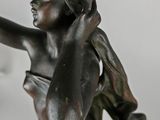 bronze statue of a boy holding a bird in his hand