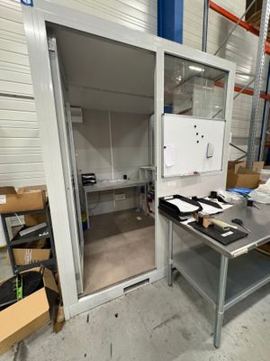une photo d'une pièce avec une table et un réfrigérateur