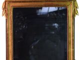 un miroir posé sur un pied, orné d'un oiseau