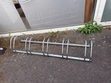 a bike rack that is sitting outside of a building
