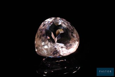 gros plan d'un diamant rose sur une surface noire