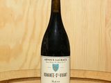 une bouteille de vin posée sur un tonneau en bois