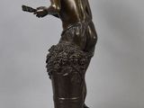 bronze statue of a man with a basket of grapes