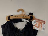 La bralette noire est suspendue à un cintre accroché au mur.