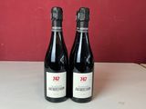 trois bouteilles de vin sont posées sur un comptoir devant un mur rouge