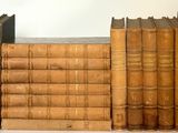 plusieurs vieux livres sont alignés sur une étagère, les uns à côté des autres