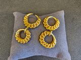 un gros plan sur un oreiller sur lequel repose une paire de boucles d'oreilles