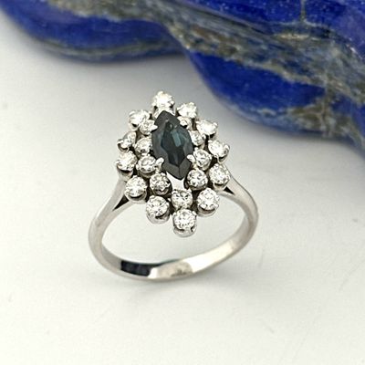 an image of a diamond and sapphire ring sitting on a rock