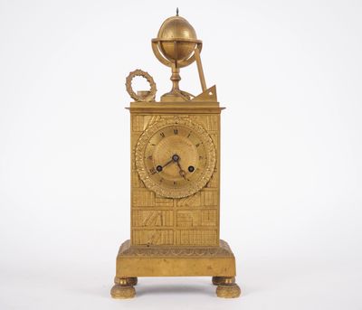 une horloge en or surmontée d'un globe terrestre