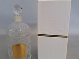 perfume bottle and box of perfume sitting on a table next to a white box