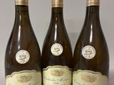 trois bouteilles de vin posées sur une table l'une à côté de l'autre