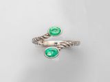 un gros plan d'une bague sertie de deux émeraudes