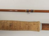 two different types of fishing rods on a white surface