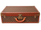 a brown and red suitcase sitting on a white surface