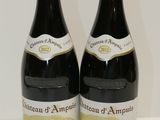 two bottles of wine sitting on a table next to each other