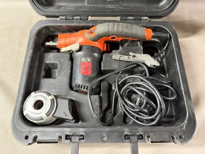 an orange and black electric drill in a case on a table