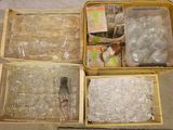 trois cartons remplis de bouteilles en plastique posés à même le sol