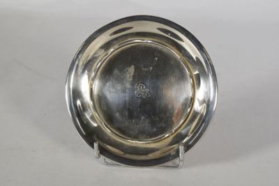 un plateau d'argent antique sur un support sur une surface blanche