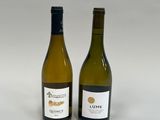 deux bouteilles de vin posées l'une à côté de l'autre sur une surface blanche