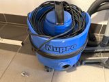 a blue and black vacuum on the floor next to a wall