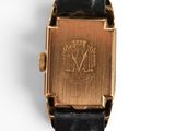 a close up of a gold watch with a black strap
