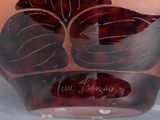 a glass vase with a design on it on a table