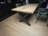 une table et des chaises en bois dans une pièce équipée d'armoires noires