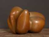 une sculpture en bois représentant deux poires posées sur une table