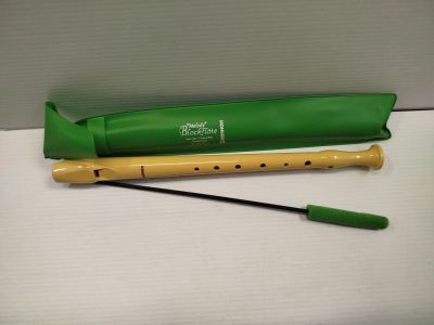 a flute and a green bag on a white surface