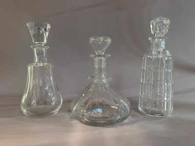 three glass decantes sitting on a table