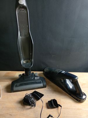 un aspirateur posé sur une table à côté d'autres objets