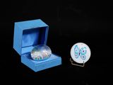 une petite boîte bleue contenant une boule de verre et une petite boîte bleue contenant une boule de verre