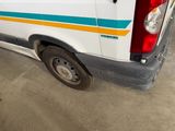 a white van with a blue and yellow stripe parked in a garage