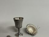 une tasse et une cuillère en argent posées l'une à côté de l'autre sur une table