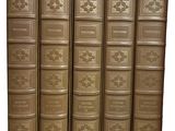 six livres anciens sont alignés sur une surface blanche