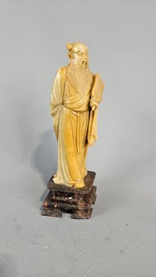 statue d'un homme à la longue barbe, vêtu d'une robe et tenant un bâton